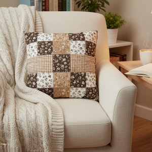 Stylish mocha brown floral pillow cover featuring a detailed patchwork layout of florals and gingham. Cozy neutral aesthetic perfect for hygge homes, farmhouse decor, and warm-toned interiors. Soft texture and unique design make this pillow cover ideal for gifting, seasonal home refreshes, or adding comfort to any space.