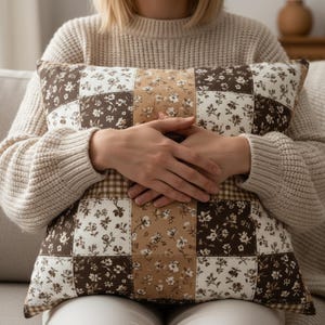 Warm mocha patchwork throw pillow cover showcasing a mix of floral and gingham squares in chocolate brown, latte beige, and soft cream. High-resolution product photo ideal for cozy decor lovers, hygge spaces, and mocha-toned interiors. Perfect as a living room pillow, bedroom accent, or dorm decor upgrade.