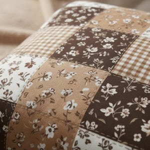 High-quality mocha patchwork pillow cover with floral prints and gingham detailing in rich brown, beige, and cream tones. Soft, cozy, and stylish neutral decor for living rooms, bedrooms, or dorm spaces. Aesthetic close-up highlighting stitching, texture, and warm tones. Perfect for hygge lovers, neutral decor, or anyone wanting a warm, inviting home look.