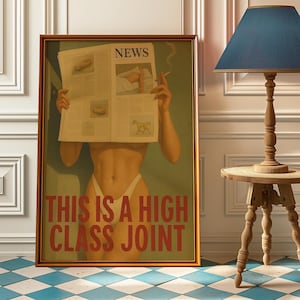 May include: Framed artwork featuring a figure holding a newspaper with the headline "NEWS." The artwork has the text "THIS IS A HIGH CLASS JOINT" in red. The artwork is in a gold frame and is displayed in a room with a blue and white checkered floor.