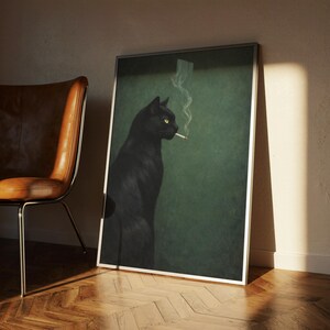 May include: A framed art print featuring a black cat with yellow eyes, smoking a cigarette. The cat is set against a dark green background. The print is in a silver frame and leans against a wall.