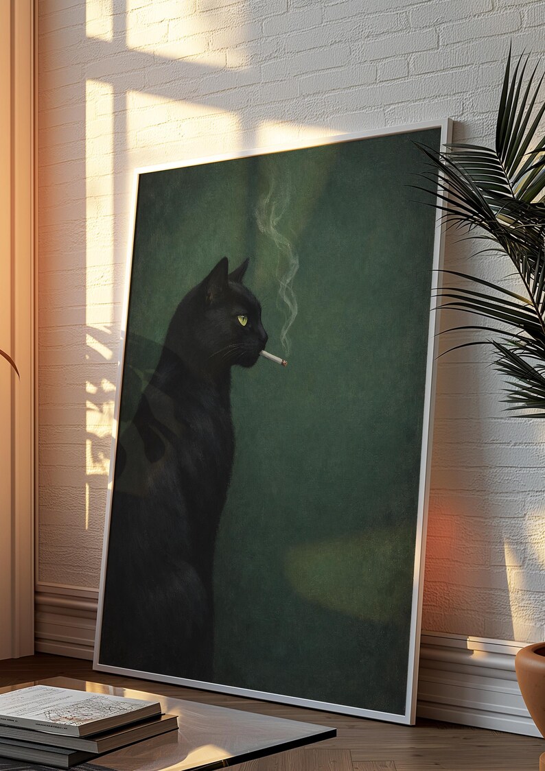 May include: Framed art print featuring a black cat with yellow eyes smoking a cigarette. The cat is set against a dark green background. The artwork is leaning against a white brick wall, with sunlight streaming in.