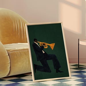 May include: Art print in a wooden frame showing a musician playing a trumpet. The illustration features a person in a dark suit with a gold trumpet against a dark green backdrop. The framed artwork is leaning against a wall.