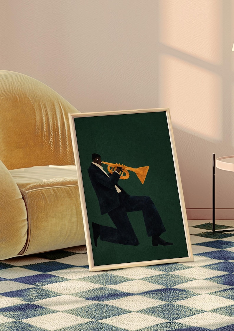 May include: Art print in a wooden frame showing a musician playing a trumpet. The illustration features a person in a dark suit with a gold trumpet against a dark green backdrop. The framed artwork is leaning against a wall.
