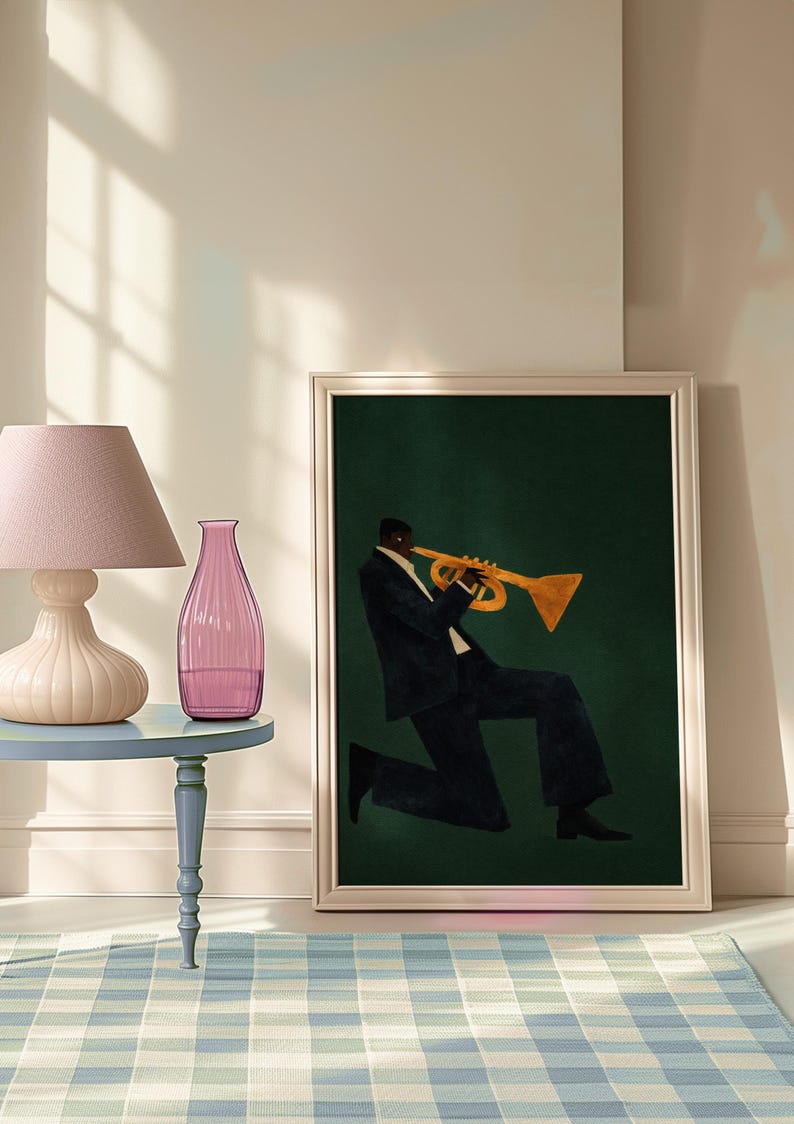 May include: Framed art print of a musician playing a trumpet. The artwork shows a person in a dark suit and white shirt, playing a gold trumpet against a dark green background. The print is in a silver frame.