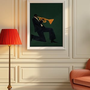 May include: A framed print shows a musician playing a trumpet. The figure wears a dark suit against a dark green backdrop. The trumpet is gold. The artwork is displayed in a room with a red lamp and a peach-coloured chair.