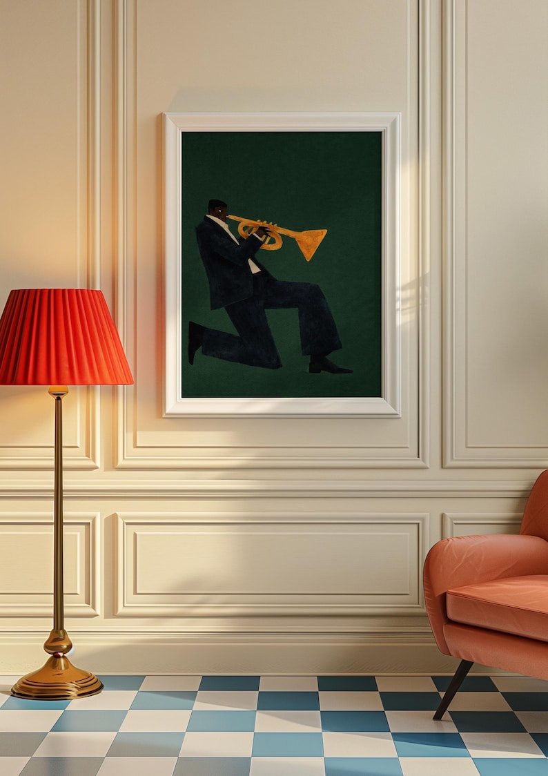 May include: A framed print shows a musician playing a trumpet. The figure wears a dark suit against a dark green backdrop. The trumpet is gold. The artwork is displayed in a room with a red lamp and a peach-coloured chair.