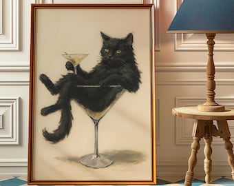 May include: Framed artwork featuring a black cat lounging in a martini glass, holding a cocktail. The cat has yellow eyes and a relaxed pose. The artwork is in a gold frame, with a light background.
