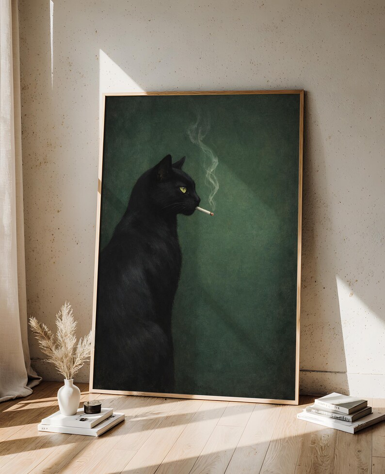 May include: A framed art print featuring a black cat with yellow eyes smoking a cigarette. The cat is set against a dark green background. The artwork is displayed in a room with a wooden floor and a vase of dried flowers.