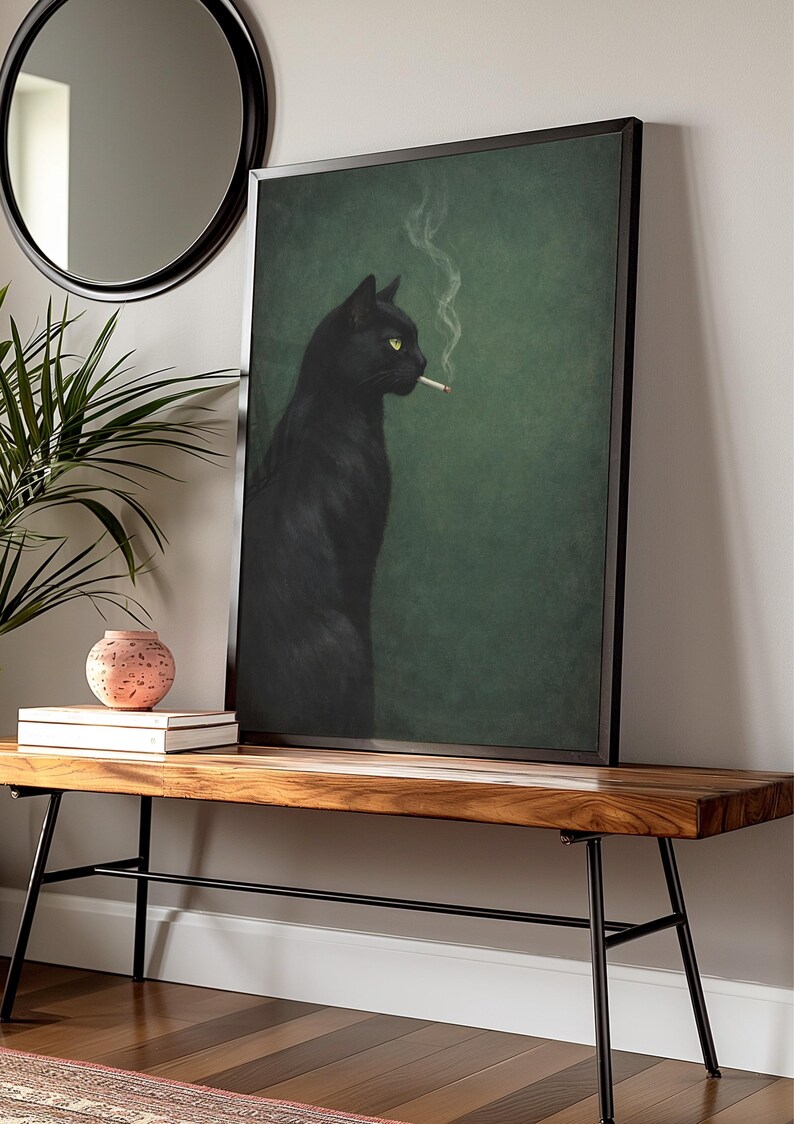 May include: A framed art print depicts a black cat with yellow eyes smoking a cigarette against a green background. The cat is the focal point, with smoke rising from the cigarette. The artwork is displayed on a wooden bench.