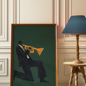 May include: A framed art print depicting a musician playing a trumpet. The figure is in a dark suit against a dark green backdrop. The frame is a warm brown colour. The artwork is displayed near a wooden side table and a lamp with a blue lampshade.