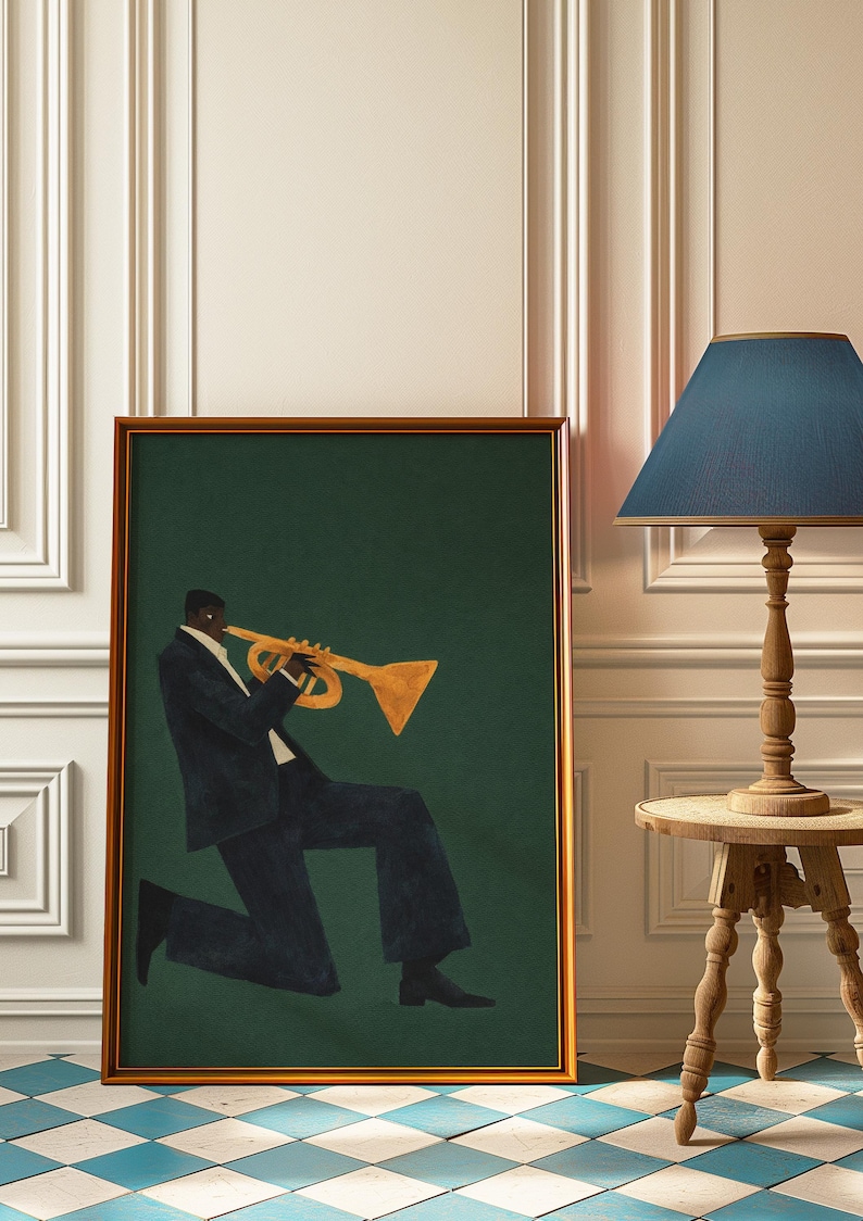 May include: A framed art print depicting a musician playing a trumpet. The figure is in a dark suit against a dark green backdrop. The frame is a warm brown colour. The artwork is displayed near a wooden side table and a lamp with a blue lampshade.