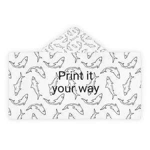 May include: White hooded towel with a black shark pattern. The towel features a repeating outline of sharks and the text "Print it your way" in black. The hood also has a shark pattern.
