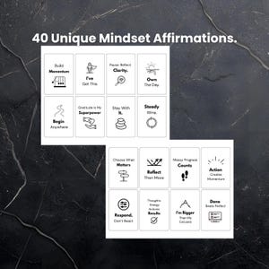 Puede incluir: Un conjunto de tarjetas blancas con texto e ilustraciones en negro, con 40 afirmaciones &uacute;nicas de mentalidad. Las tarjetas incluyen frases como "Construir impulso", "Puedo con esto" y "Aprovechar el d&iacute;a". El fondo es una superficie oscura y texturizada.