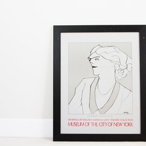 May include: Black and white line drawing of a woman's face in profile, framed in a black frame. The text below the drawing reads "DRAWINGS BY WILLIAM AUERBACH LEVY THEATRE COLLECTION MUSEUM OF THE CITY OF NEW YORK".