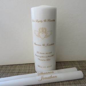 May include: White unity candle with the inscription "Love, Loyalty & Friendship" and a Claddagh design. The candle also has the names "Shannon & Jonathan" and the date "March 23, 2019". Two smaller white candles are included, each with the name "Shannon" and "Jonathan" inscribed on them.