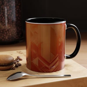 May include: A brown and orange patterned ceramic mug with a black handle and interior. The mug is on a wooden board with a spoon and a macaron. The mug's design features geometric shapes.