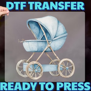 May include: A watercolor-style DTF transfer featuring a baby carriage in shades of blue. The carriage has a hood and spoked wheels. The text "DTF TRANSFER" and "READY TO PRESS" are displayed in blue.