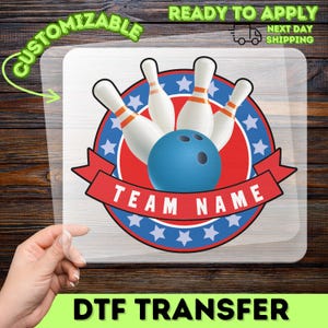 May include: A DTF transfer featuring a bowling design. The design includes a blue bowling ball, white bowling pins with orange stripes, and a red banner with the text "TEAM NAME". The design is set within a red and blue circle with stars. The words "CUSTOMIZABLE" and "READY TO APPLY" are also present.
