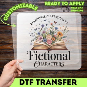 May include: A clear DTF transfer with the text "Emotionally Attached to Fictional Characters" above an open book with a floral arrangement. The transfer is customizable and ready to apply.