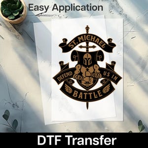 May include: A DTF transfer featuring a black and gold emblem with the text "ST. MICHAEL" and "DEFEND US IN BATTLE". The emblem includes a knight's helmet and wings. The words "Easy Application" are at the top.
