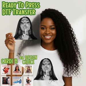 May include: A DTF (Direct to Film) transfer featuring a black and white image of Cardi B with a finger to her lips. The image is held by a person. The text "READY TO PRESS DTF TRANSFER" and "46 DESIGN CHOICE" are visible.