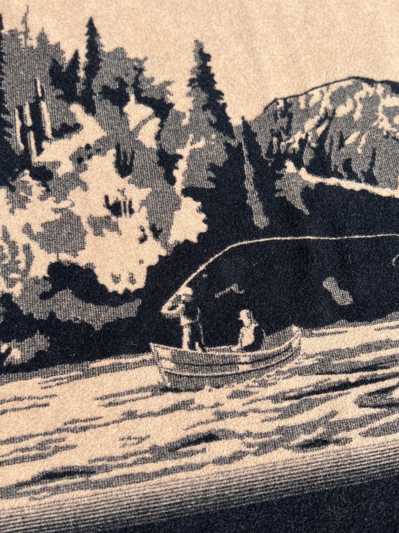 Puede incluir: Un tejido de color beige y negro con un estampado gr&aacute;fico de una peque&ntilde;a embarcaci&oacute;n con dos figuras sobre el agua. El fondo muestra un denso bosque de &aacute;rboles altos y una cordillera, representados en un esquema de dos colores contrastados.