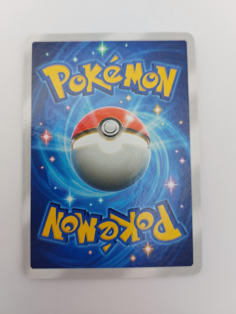 May include: Reverse side of a Pok&eacute;mon trading card. The card has a blue background with a swirling pattern and white stars. The Pok&eacute;mon logo is in yellow, with a red and white Pok&eacute; Ball design in the centre.
