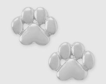 May include: A pair of silver-colored paw print stud earrings. Each earring features a detailed paw print design with five rounded pads. The earrings are set against a light gray background, highlighting their shiny, metallic finish.