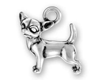 May include: Silver charm of a chihuahua dog standing with its tail up. The charm has a loop at the top for attaching to a necklace or bracelet.