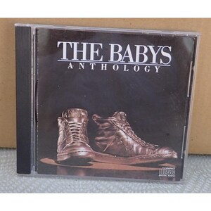May include: A music CD case featuring the album title The Babys Anthology in white text on a black background. The cover art displays a pair of metallic bronze high-top sneakers centered at the bottom with a Compact Disc logo in the corner.
