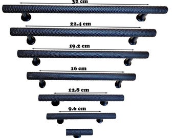 Può includere: Un set di maniglie per porte nere strutturate in varie dimensioni, da 9,6 cm a 32 cm di lunghezza. Ogni maniglia ha un'impugnatura cilindrica e staffe di montaggio curve, per armadi o porte.