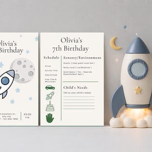 May include: Two rectangular white birthday invitation cards featuring a rocket ship and moon graphic with the text Olivia's 7th Birthday, alongside a three-dimensional cream and blue rocket ship lamp emitting a warm glow from its base.