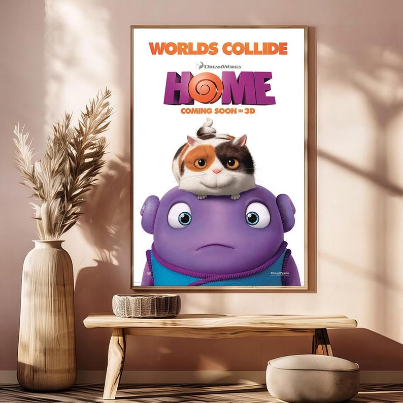 May include: A framed movie poster for "Home" with the text "Worlds Collide." The poster features a purple alien with large blue eyes, topped by a cat-like creature. The DreamWorks logo is visible.