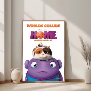 May include: A framed movie poster for "Home" featuring a purple alien character with a cat on its head. The poster has the text "Worlds Collide" and "Home" in large letters, with "Coming Soon in 3D" below.