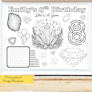 May include: A framed black and white party placemat with the text "Emily's 8th Birthday She's A Gem." The placemat features gem and crystal illustrations, a word search, a maze, and a connect-the-dots activity.