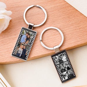 May include: Two rectangular metal keychains featuring a film strip design. One keychain displays two color photographs of a couple, while the other shows three black and white photographs of a couple, both attached to silver metal split rings.