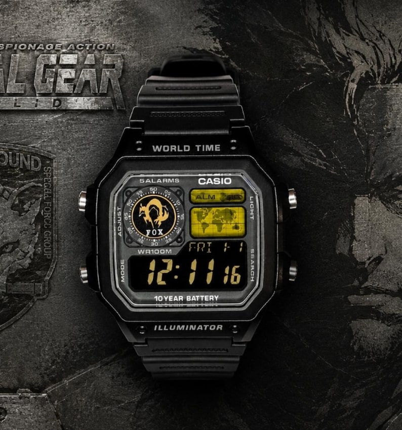 May include: A black Casio digital watch featuring a square case, a resin strap, and a world time display. The watch face includes a yellow-tinted map, a circular FOX logo, and a digital screen showing the time 12:11:16, with 10 YEAR BATTERY text.