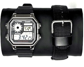 Relógio digital Casio Royale AE1200 com caixa de metal personalizada e função de hora mundial.