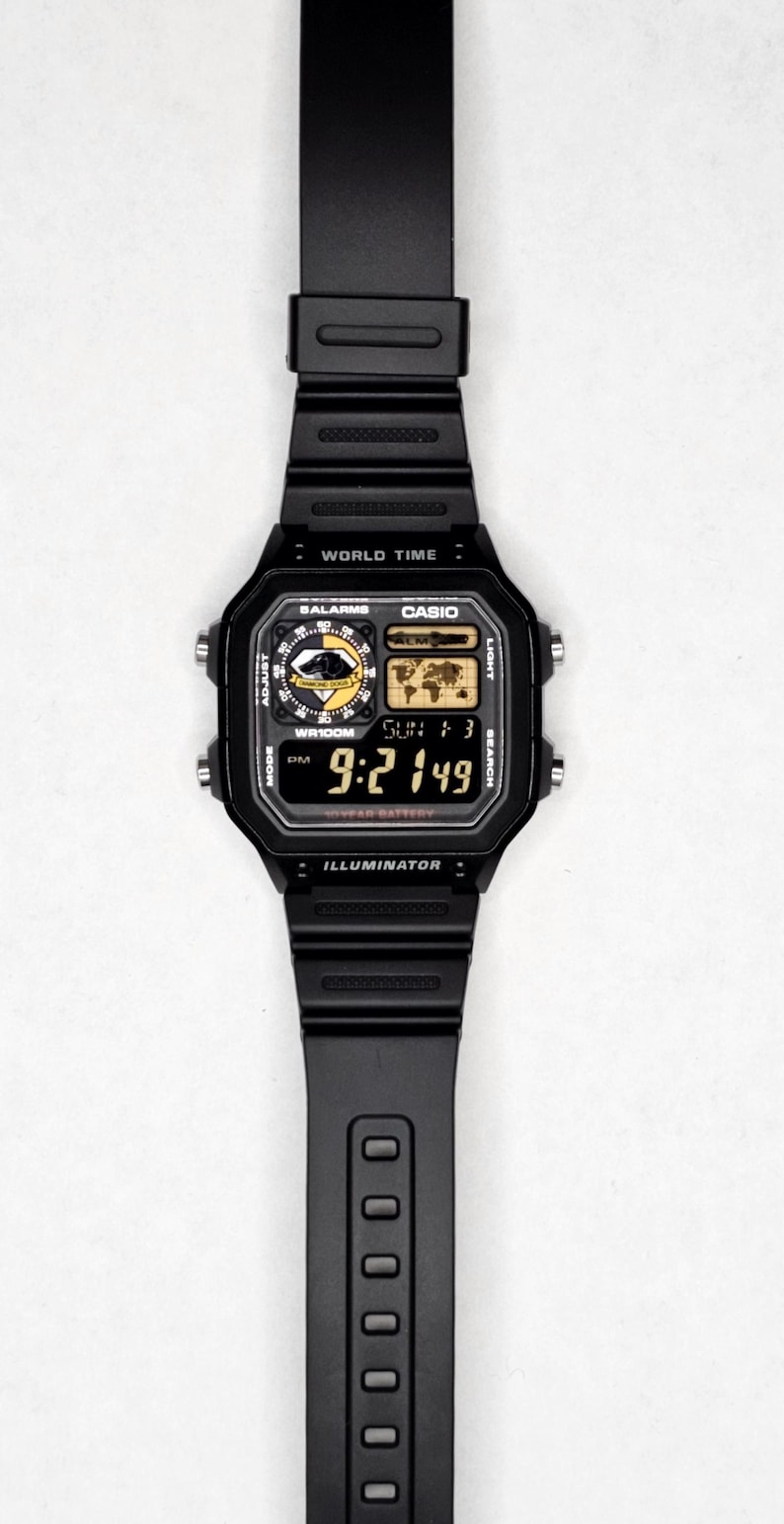 May include: Black digital watch with a rectangular face and black band. The watch face displays the time, date, and various functions. The watch has the word "CASIO" on the face.
