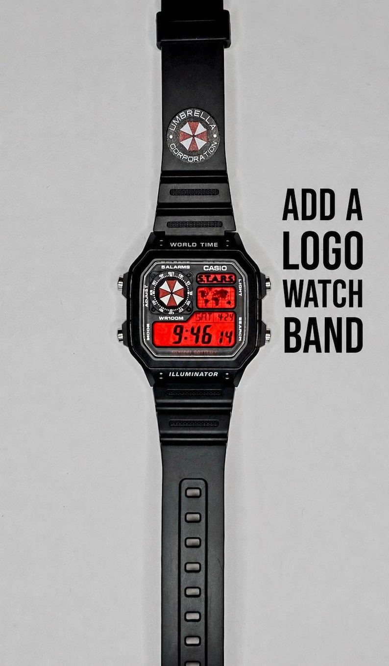 May include: Black digital watch with a red display showing the time. The watch band features the Umbrella Corporation logo. The text "ADD A LOGO WATCH BAND" is displayed next to the watch.