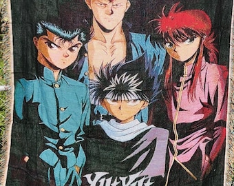 Può includere: Coperta nera tessuta con quattro personaggi anime di Yu Yu Hakusho. I personaggi hanno colori di capelli distinti: nero, rosso e blu. La coperta ha un bordo sfrangiato e il titolo dello show è stampato in bianco.