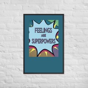 Puede incluir: Una lámina de arte mural rectangular enmarcada que presenta un bocadillo de estilo cómic en azul claro con el texto "FEELINGS ARE SUPERPOWERS" en letras de color morado oscuro. El fondo incluye detalles en amarillo, morado y verde.