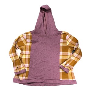May include: A purple hooded sweatshirt with a quilted texture and a plaid pattern on the sleeves. The sleeves are a mix of brown and yellow plaid.