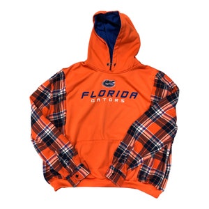 May include: Orange hoodie with plaid sleeves and the text "FLORIDA GATORS" in blue on the front.