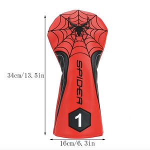 Op de afbeelding: Rode en zwarte golfclubhoofdbeschermer met een spinnenwebontwerp en het woord "SPIDER". De hoes is 34 cm lang en 16 cm breed, met het nummer "1" aan de onderkant.