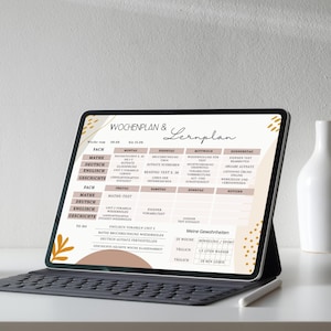 May include: A digital tablet displaying a weekly study plan with subjects like math, German, English, and history. The screen shows a schedule with daily tasks and a section for personal habits. The tablet rests on a keyboard.