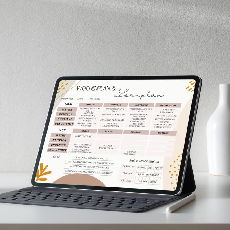 May include: A digital tablet displaying a weekly study plan with subjects like math, German, English, and history. The screen shows a schedule with daily tasks and a section for personal habits. The tablet rests on a keyboard.
