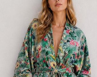 May include: A long-sleeved, calf-length robe featuring a vibrant floral pattern in shades of green, pink, and yellow. The garment includes a matching tie belt at the waist, two front patch pockets, and a shawl collar, crafted from a soft velvet fabric.