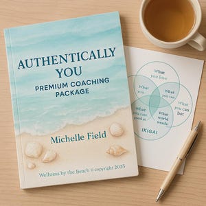 May include: A book titled "AUTHENTICALLY YOU PREMIUM COACHING PACKAGE" with a beach scene cover, seashells, and the author's name, Michelle Field. A diagram with overlapping circles and the word "IKIGAI" is next to the book, along with a pen and a cup of tea.
